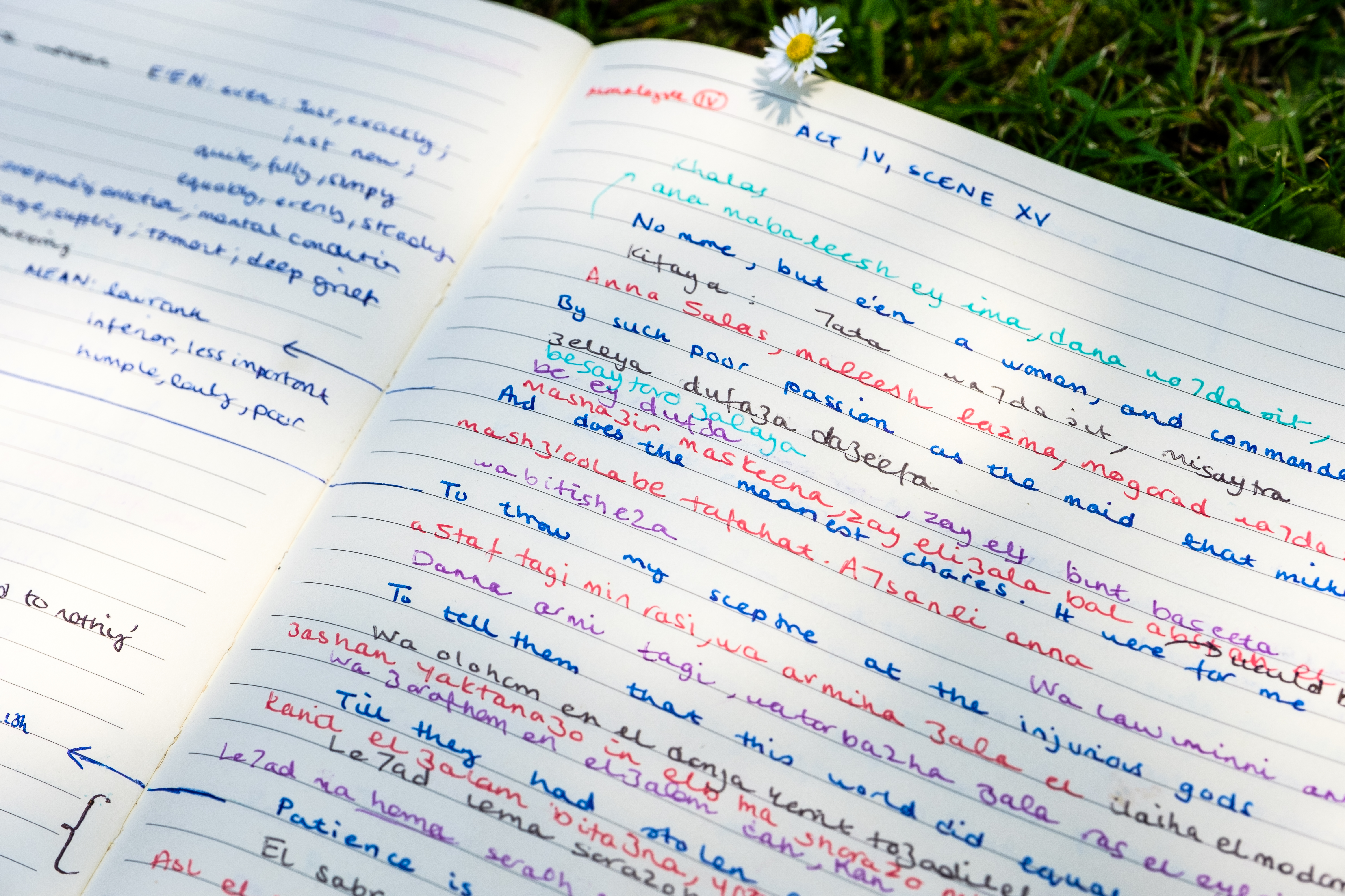 A close-up photo of a notebook with English and Arabic text