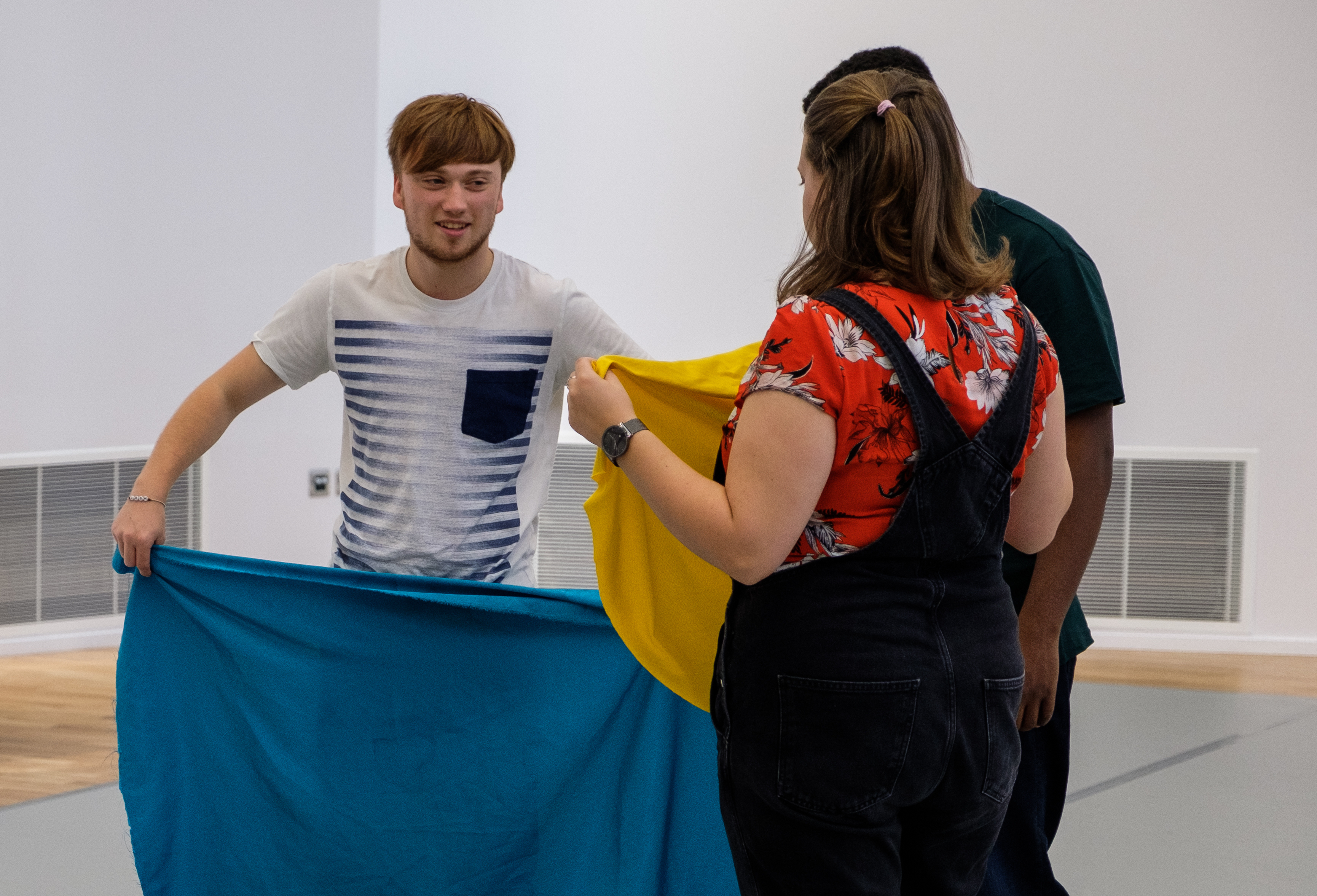 Participants in a drama workshop with colourful fabric