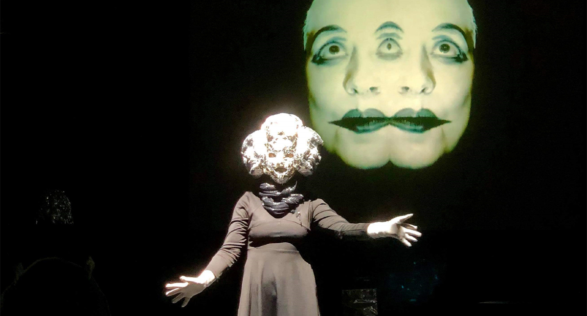 Figure wearing mask in front of an image of a face